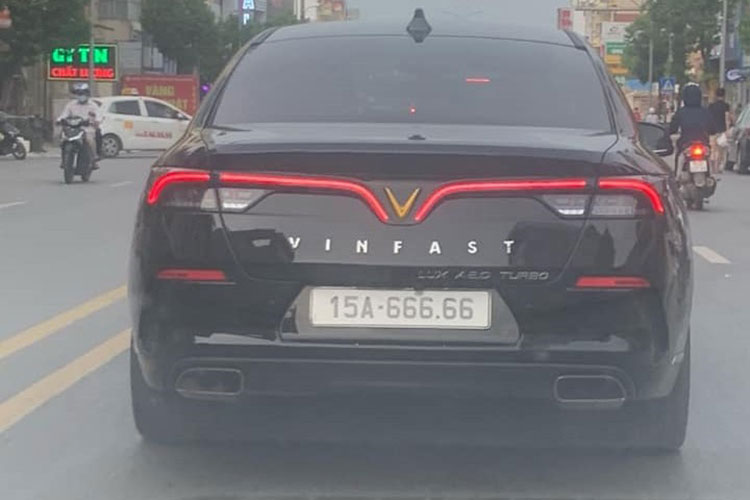 Chiếc xe VinFast LUX A2.0 màu đen di chuyển trên đường phố Hải Phòng với chiếc biển số 